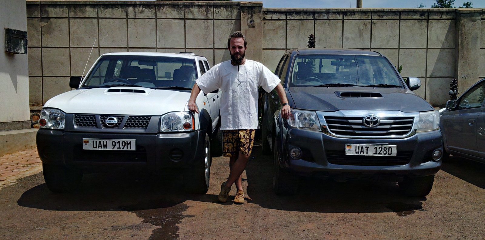 Dimitry between the company pickups in Uganda
