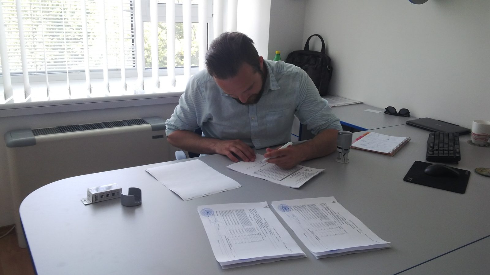 Dimitry signing documents at the Wave office